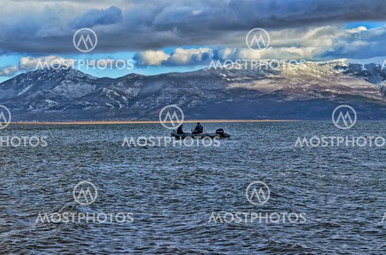 Police patrol on lake at winter, mountain in snow