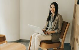 Professional woman working on a laptop in a cozy modern...