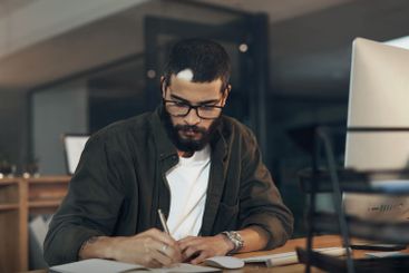 Businessman, writing and night with book on computer for...
