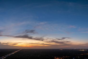 Evening sunset sky with colorful clouds over dark land....