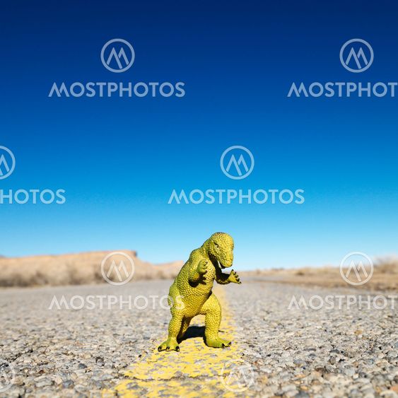 Toy dinosaur in road.