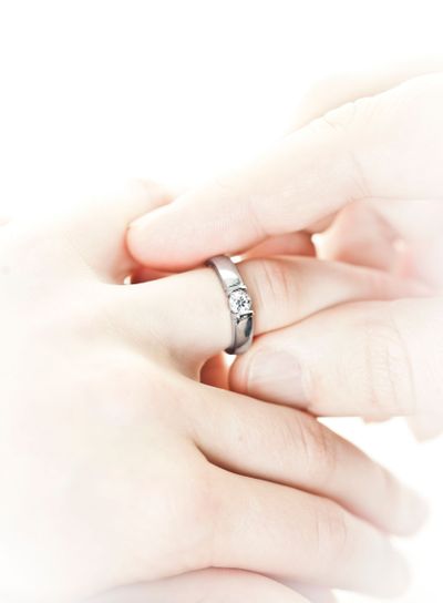 Man putting engagement ring on finger