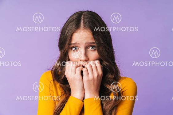 Image of young caucasian woman being scared and biting...