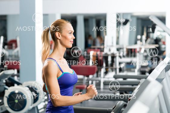 attractive young woman runs on a treadmill