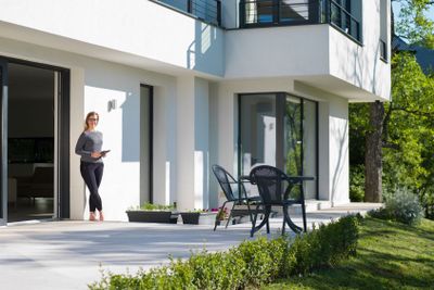 women using tablet computer in front of luxury home villa