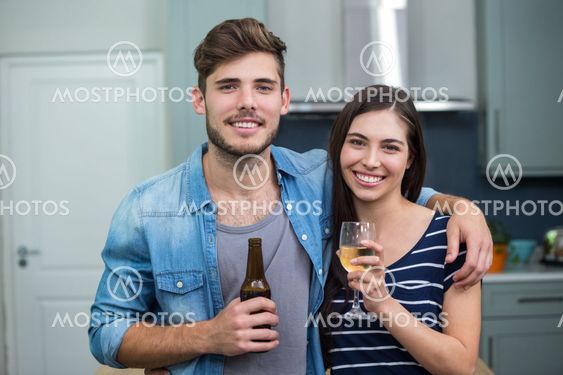 Happy friends enjoying drinks at home