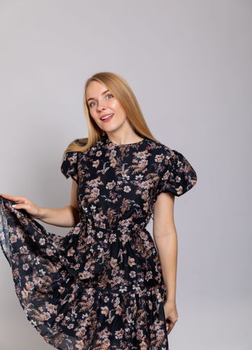 Beautiful woman smiling in summer dress on gray background