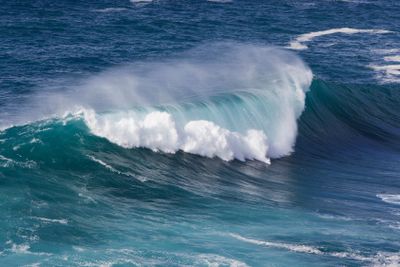 En våg bryts vid stranden