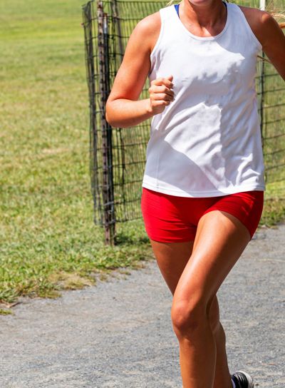 Cross country female racing in white top and red shorts...