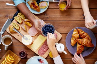 people having breakfast at table with food