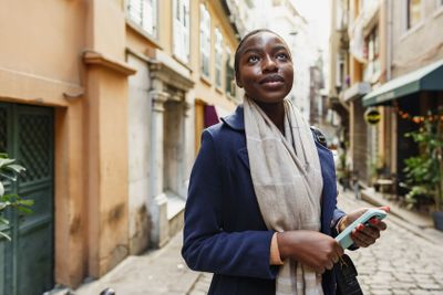 Young african woman walks alone on europe street