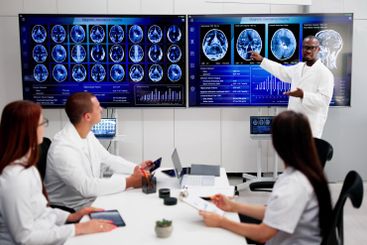 Doctors In Clinic Looking At Brain MRI Scan