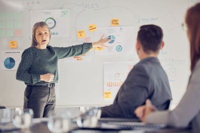 Businesswoman leadership, whiteboard presentation to...