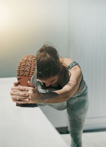 Woman reaching feet for fitness, training outdoor and...