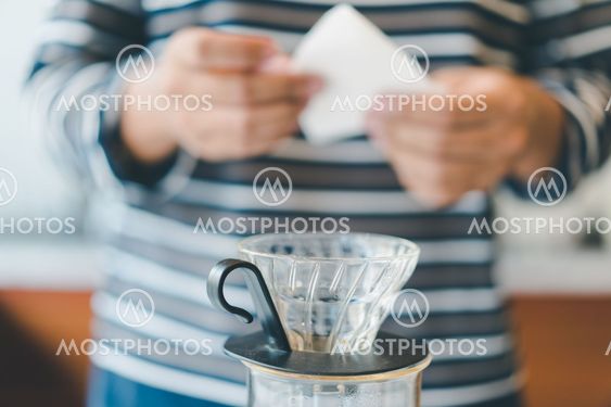barista prepare filter paper on dripper to brew coffee