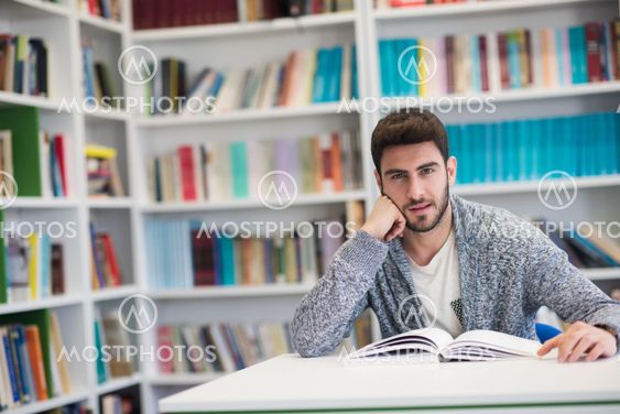 portrait of student while reading book in school library
