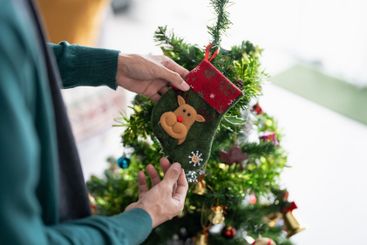 Happy hands Decorating Christmas tree for xmas holiday.