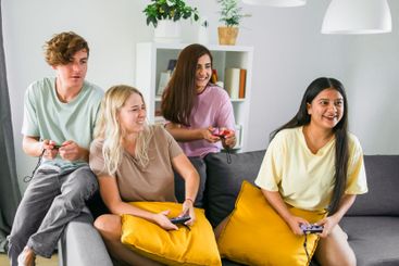 Cheerful group of friends playing video games together...
