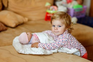 Adorable cute little toddler girl playing with doll....