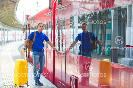 Young man with baggage at a train station near Aeroexpress