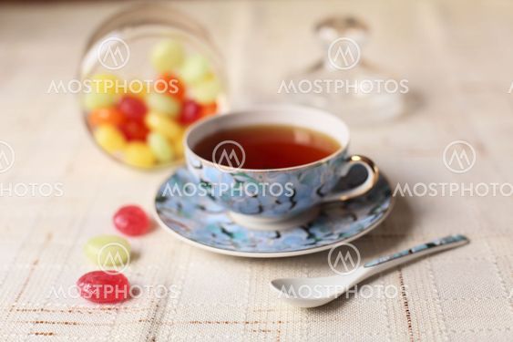 Tea with coloured sugar candies in a glass can