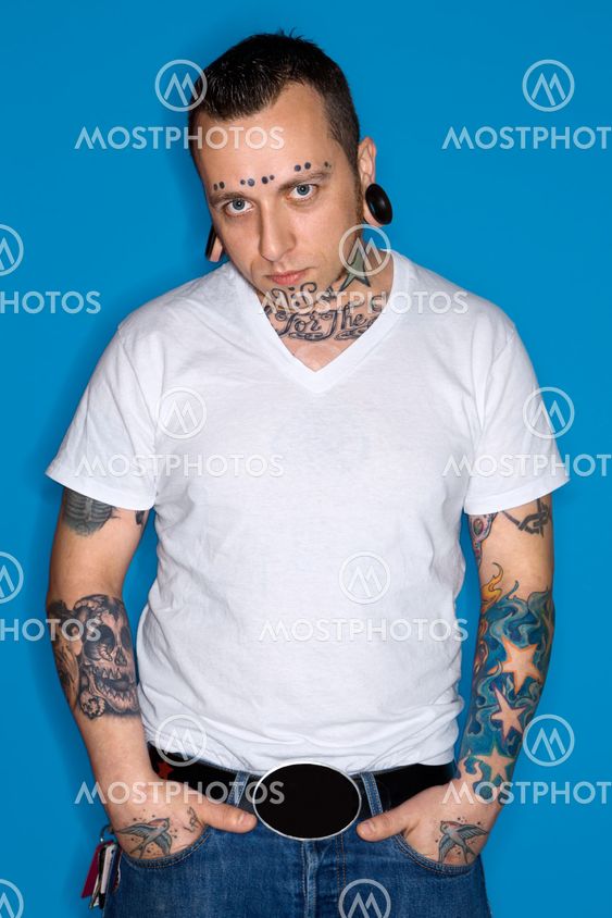 Man with tattoos and piercings.