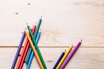 Colorful arrangement of colored pencils on a wooden...