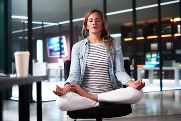 Young Businesswoman Sitting On Chair Meditating