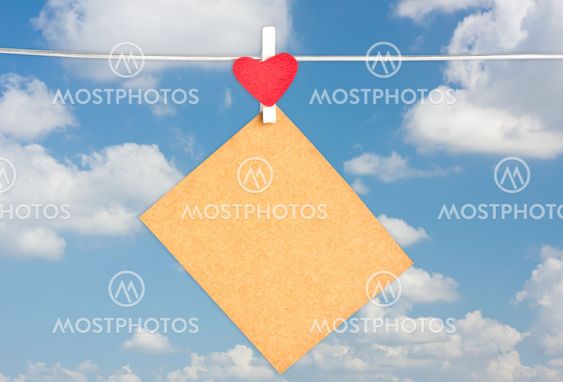 blank brown paper hanging on the clothesline with blue sky background.