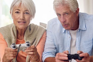 Video game, home and senior couple play together for...