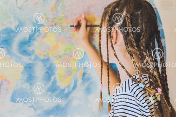 Teenage girl with pigtails makes pencil marks on the...
