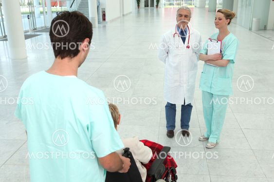 hospital worker taking care of senior patient in a wheelchair
