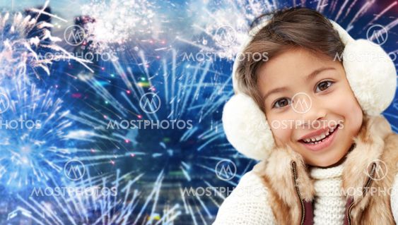 happy little girl wearing earmuffs over firework