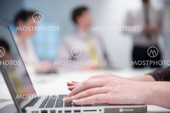 woman hands typing on laptop keyboard at business meeting