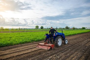 A man farmer works in a farm field. Cultivating the soil...