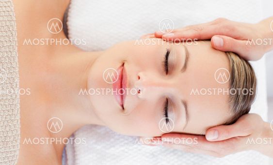 Young relaxed woman receiving a head massage