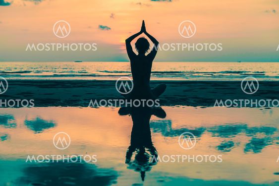 Yoga Silhouette. Woman on the beach with reflection in water.