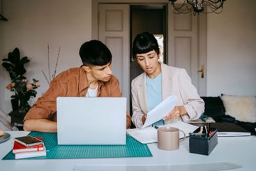 Male and female business professionals discussing over...