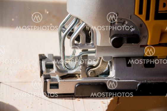 Joiner works on the machine with the wooden product...