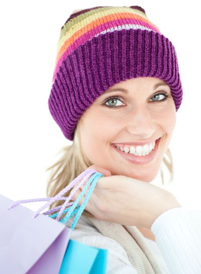 Brght woma holding shopping bags wearing a colourful hat 