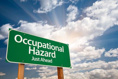 Occupational Hazard Green Road Sign Over Clouds