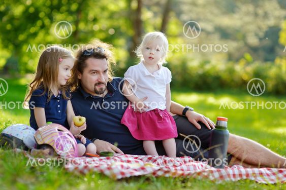Young father and his daughters having a picnic