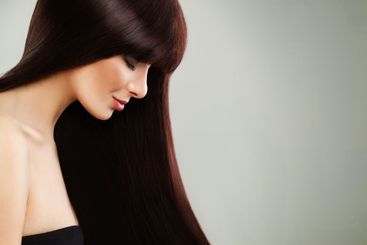 Elegant young brunette woman with long shiny silky...