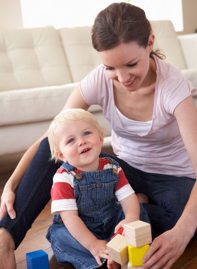 Mother And Son Playing With Coloured Blocks At Home