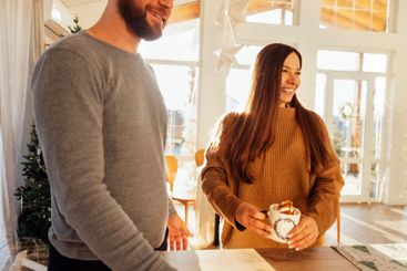 A young married couple drinks coffee at home. A handsome...