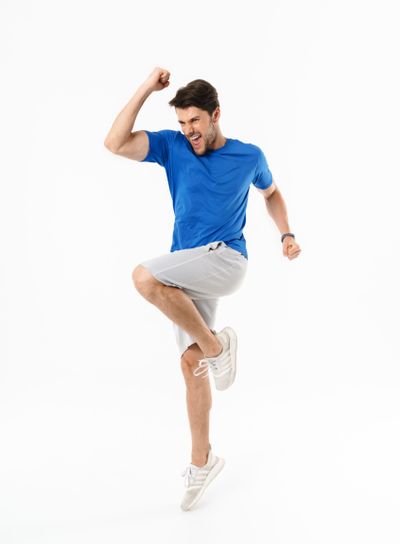 Full length photo of excited man in shorts and t-shirt...