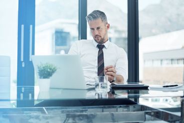Serious, business man and laptop in office for company...
