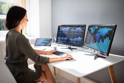 Stock market broker analyzing graph on computer