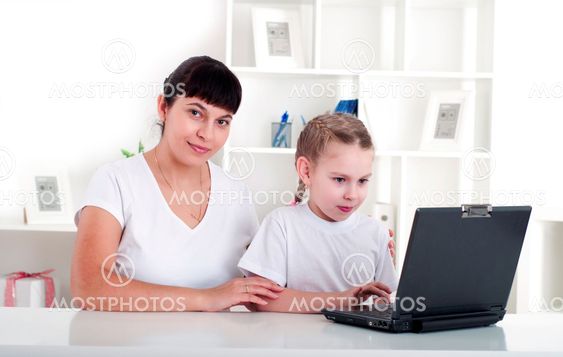 Mom and daughter are working together for a laptop