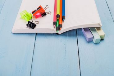 Colorful stationery supplies arranged on a notebook with...